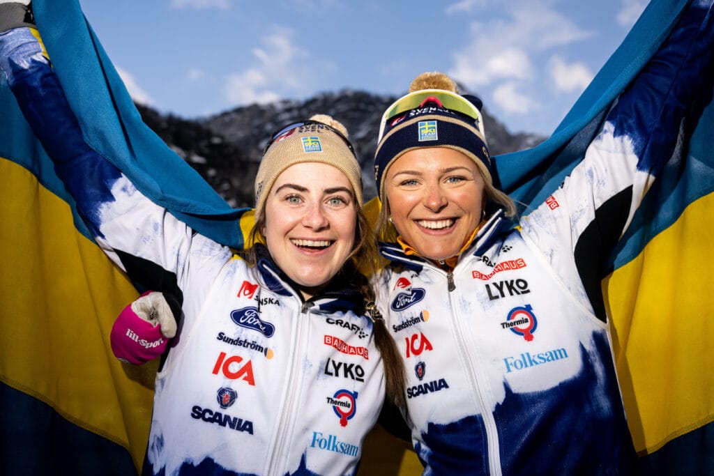 Ebba Andersson (gold) and Frida Karlsson (silver) of Sweden celebrate with the Swedish flag after the Women's Cross Country Skiing Skiathlon during the FIS Nordic Ski World Championships on February 25, 2023 in Planica.