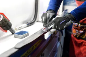 170221 En vallare skrapar bort överflödigt parafin från en skida i sveriges vallatrailer inför skid-VM den 21 februari 2017 i Lahtis. Foto: Carl Sandin / BILDBYRÅN / kod CS / 57999_60