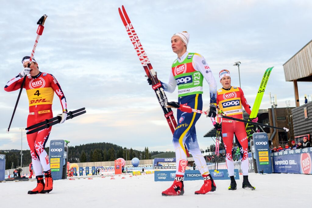 251205 Oskar Opstad Vikeof Norway, Alvar Myhlback of Sweden and Johannes Høsflot Klæboof Norway celebrate after the men's sprint final during the FIS Cross-Country World Cup on December 5, 2025 in Trondheim. Photo: / kod MT / MT0910