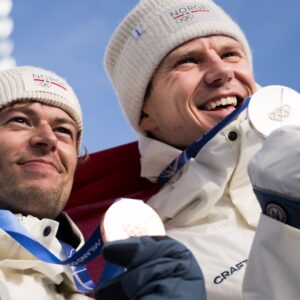 260213 Bronze medalist Sturla Holm Lægreid of Norway and silver medalist Vetle Sjåstad Christiansen of Norway celebrate with their medals in men's biathlon 10 km sprint during day 7 of the 2026 Winter Olympics on February 13, 2026 in Anterselva. Foto: Mathias Bergeld / BILDBYRÅN