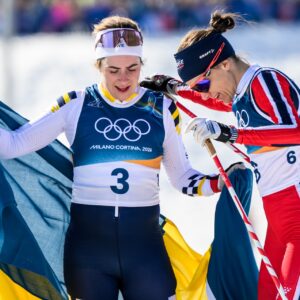 Ebba Andersson of Sweden and Heidi Weng of Norway celebrate after competing in the women's 50km classic technique cross-country skiing race during day 16 of the 2026 Winter Olympics on February 22, 2026 in Val di Fiemme. Photo: Maxim Thore / BILDBYRÅN